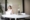 흰색 민소매 드레스 입은 여성이 Macbook 앞 의자에 앉아 있는 모습